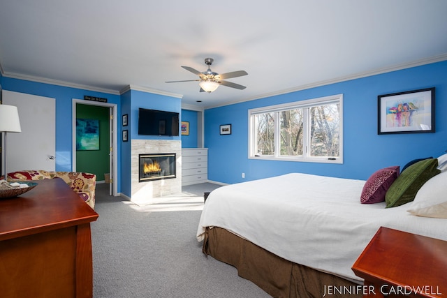 carpeted bedroom featuring crown molding, a fireplace, baseboards, and a ceiling fan