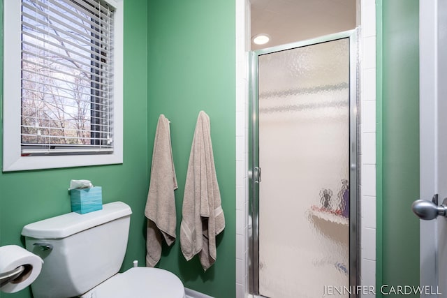 bathroom featuring toilet and a stall shower