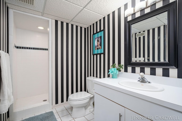 full bathroom with tiled shower, vanity, toilet, and wallpapered walls