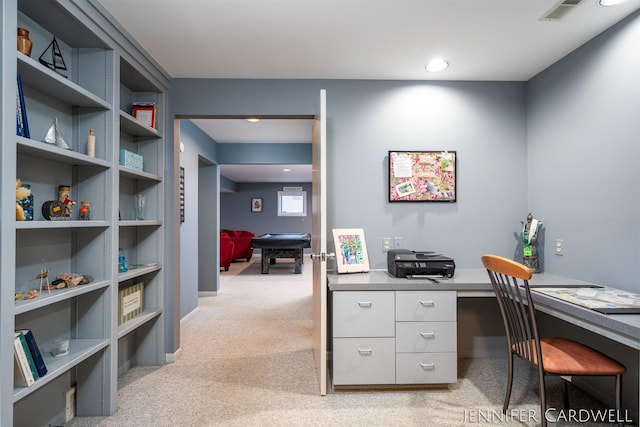 office area featuring built in desk, visible vents, and light colored carpet