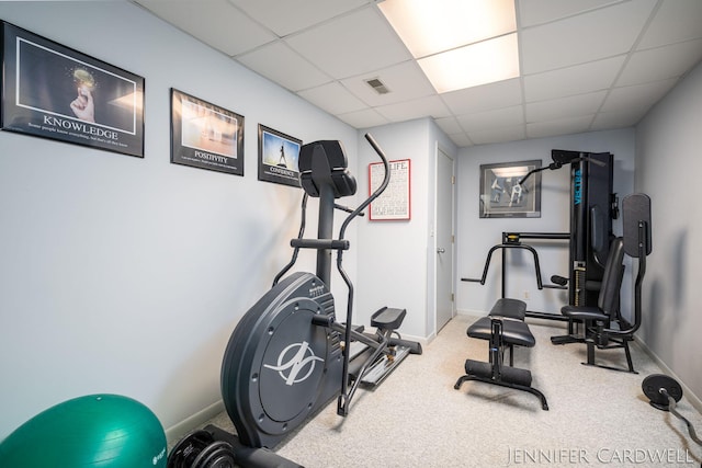 exercise area with a paneled ceiling, visible vents, and baseboards