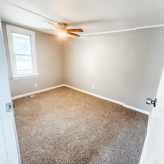 unfurnished room featuring carpet floors, visible vents, and baseboards