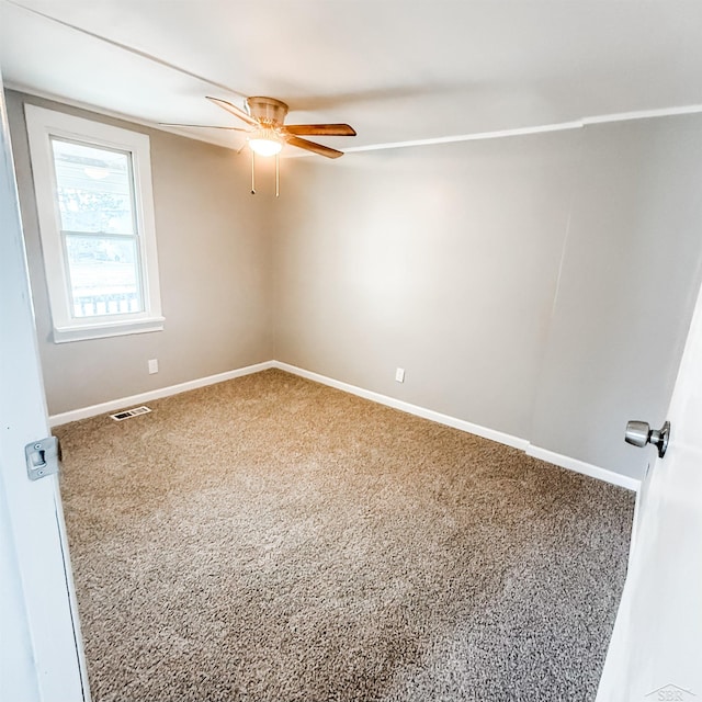 spare room featuring baseboards, a ceiling fan, carpet flooring, and visible vents