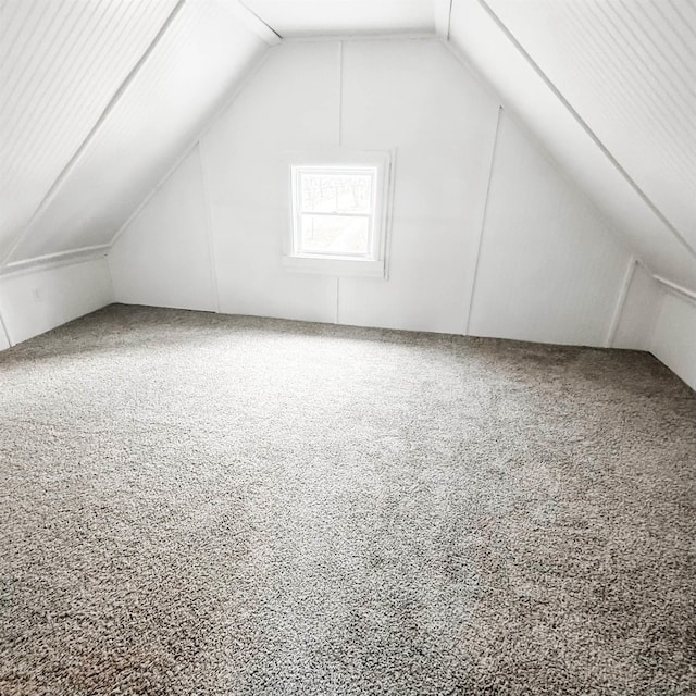 bonus room featuring vaulted ceiling and carpet flooring