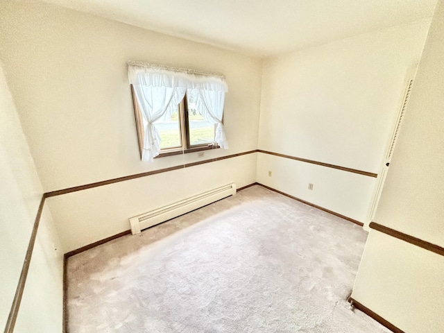 carpeted spare room with a baseboard radiator and baseboards