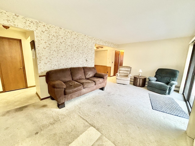 carpeted living room with wallpapered walls, a baseboard radiator, and baseboards