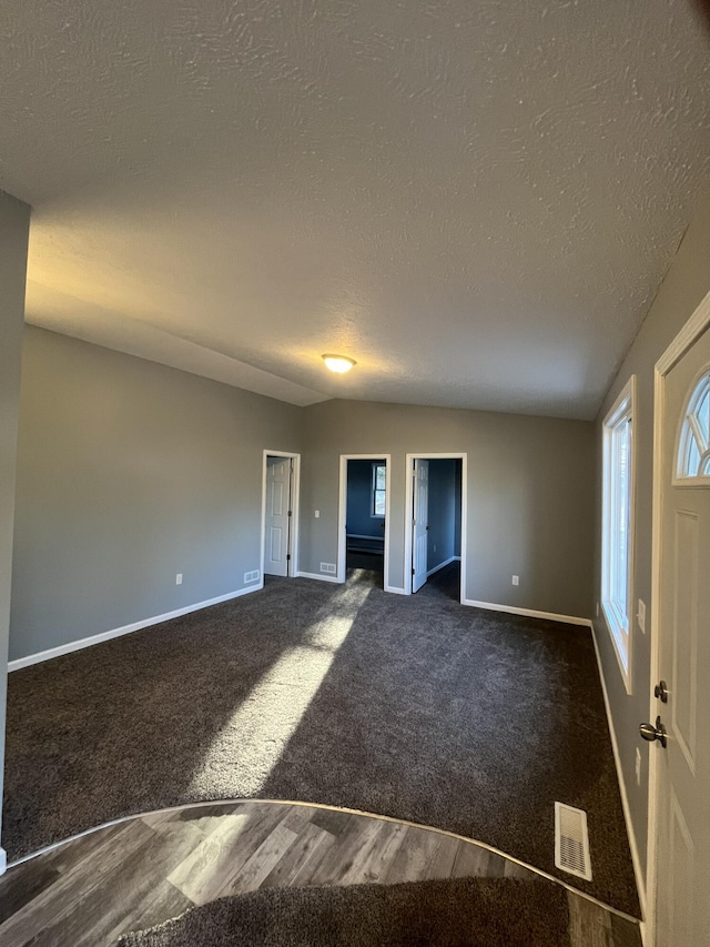 unfurnished room featuring baseboards, visible vents, and a textured ceiling