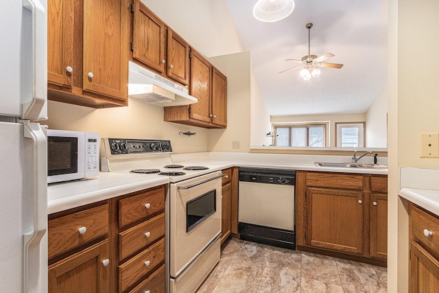 kitchen featuring under cabinet range hood, white appliances, a sink, light countertops, and brown cabinets