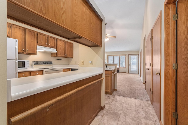 kitchen featuring light countertops, brown cabinetry, ceiling fan, white appliances, and under cabinet range hood