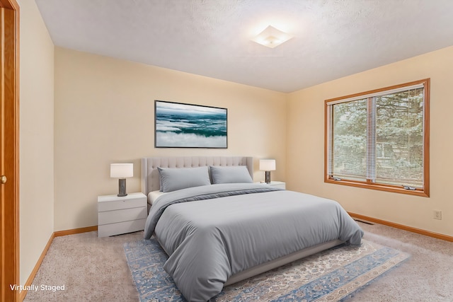 carpeted bedroom with visible vents, a textured ceiling, and baseboards