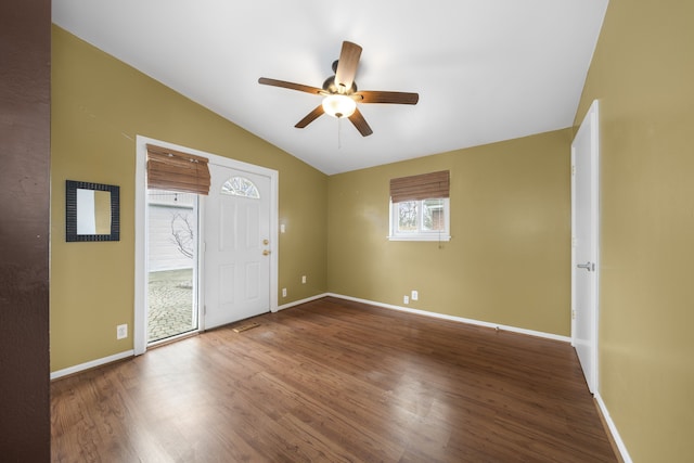 interior space featuring a ceiling fan, vaulted ceiling, wood finished floors, and baseboards