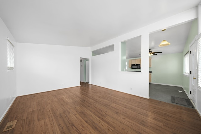 unfurnished room featuring visible vents, dark wood-type flooring, baseboards, vaulted ceiling, and a ceiling fan