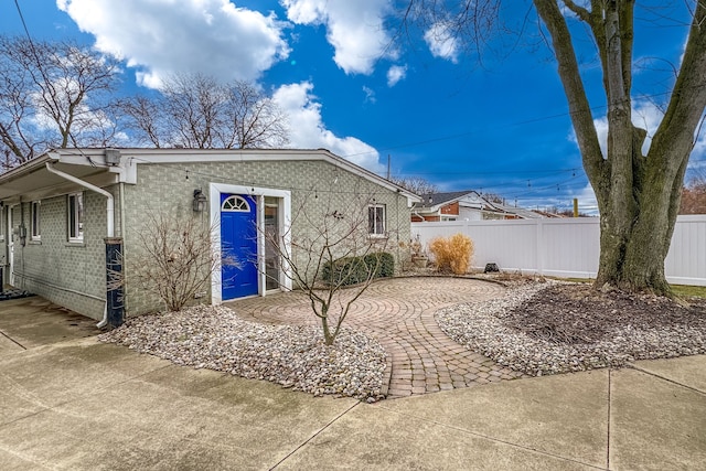 rear view of house with fence and brick siding