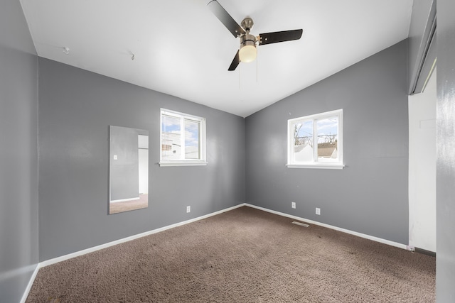 carpeted spare room with baseboards, ceiling fan, and vaulted ceiling