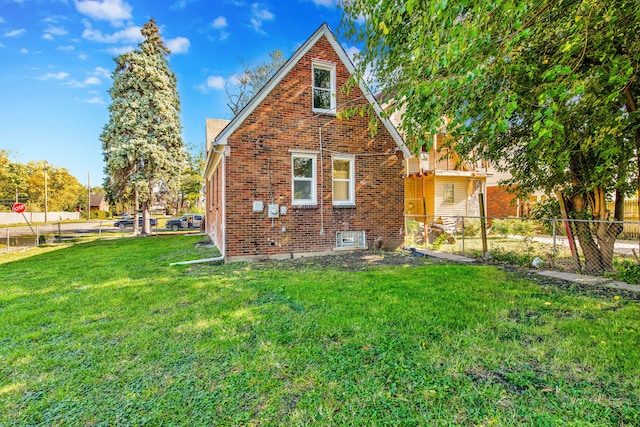 view of home's exterior with a yard, fence, and brick siding