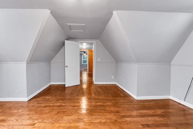 additional living space featuring lofted ceiling, wood finished floors, and baseboards