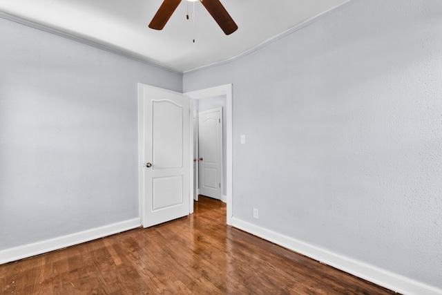 empty room featuring a ceiling fan, baseboards, and wood finished floors