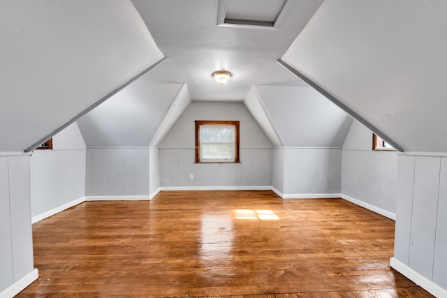 bonus room featuring lofted ceiling, baseboards, and wood finished floors