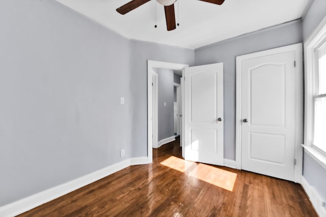 unfurnished bedroom with a ceiling fan, baseboards, and wood finished floors