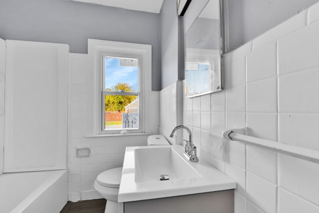 bathroom featuring vanity, toilet, and tile walls