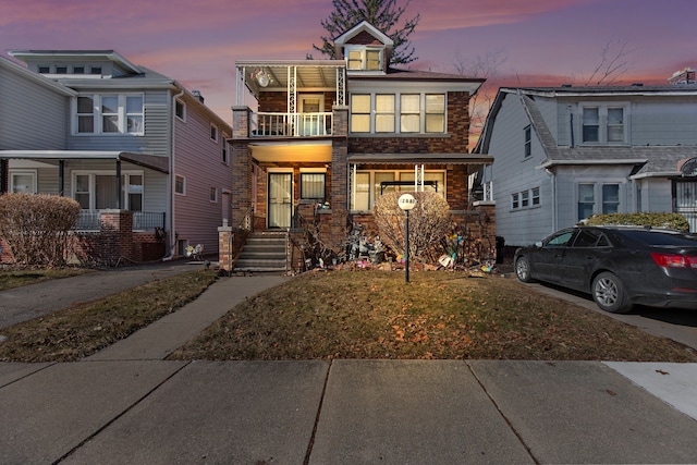 view of front of property featuring a balcony and brick siding