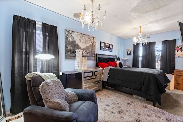 carpeted bedroom featuring a notable chandelier, a textured ceiling, and visible vents