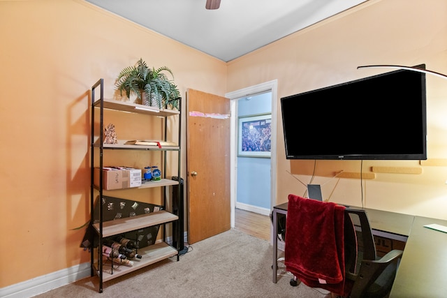 carpeted home office featuring baseboards and a ceiling fan