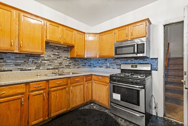 kitchen featuring backsplash, stainless steel appliances, light countertops, and a sink