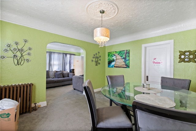 dining area with arched walkways, radiator, and a textured wall