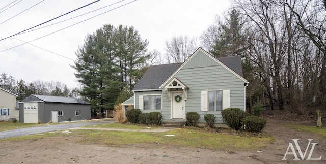 view of front of home featuring driveway and roof with shingles