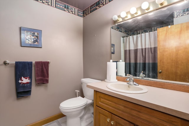 bathroom featuring curtained shower, vanity, and toilet