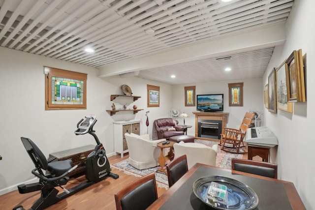 workout area with visible vents, baseboards, wood finished floors, a fireplace, and recessed lighting