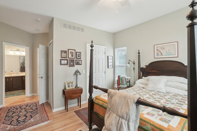 bedroom with baseboards, visible vents, ceiling fan, ensuite bathroom, and light wood-type flooring