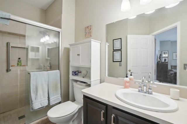 bathroom with toilet, a shower stall, and vanity