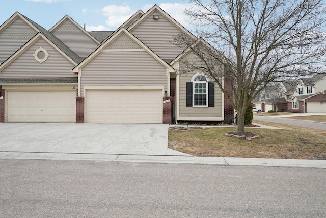 traditional-style home with a garage, concrete driveway, brick siding, and a front lawn