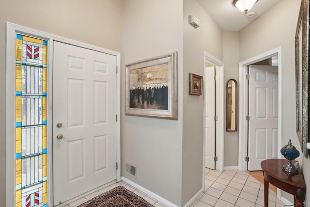 foyer entrance featuring light tile patterned floors, visible vents, and baseboards