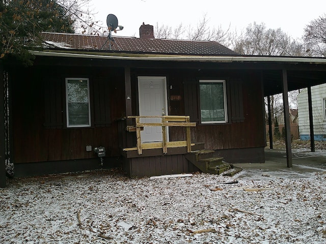 view of front of home with covered porch and a chimney