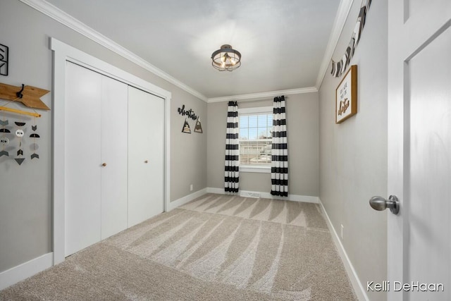 unfurnished bedroom featuring baseboards, carpet floors, a closet, and crown molding