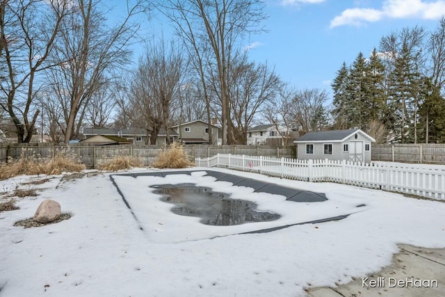 yard covered in snow with a fenced backyard and an outbuilding