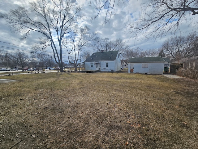 view of yard featuring fence and an outbuilding