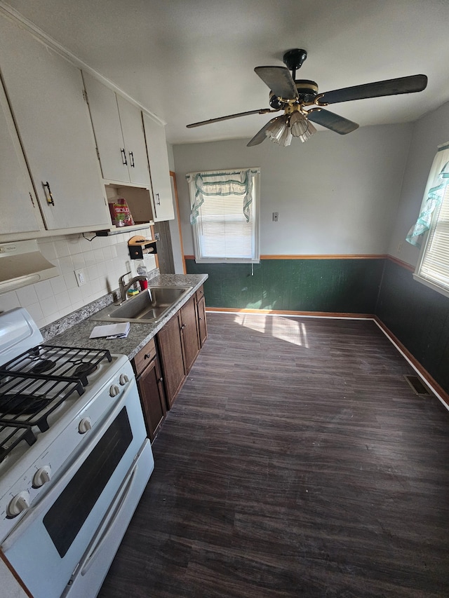 kitchen with dark wood-style floors, a wealth of natural light, a sink, and gas range gas stove