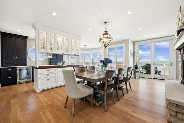 dining area featuring recessed lighting, beverage cooler, plenty of natural light, and light wood-style flooring