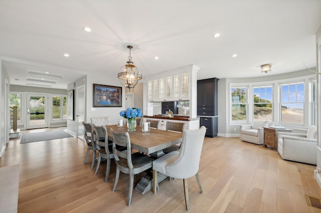 dining space featuring baseboards, recessed lighting, light wood-type flooring, and a healthy amount of sunlight