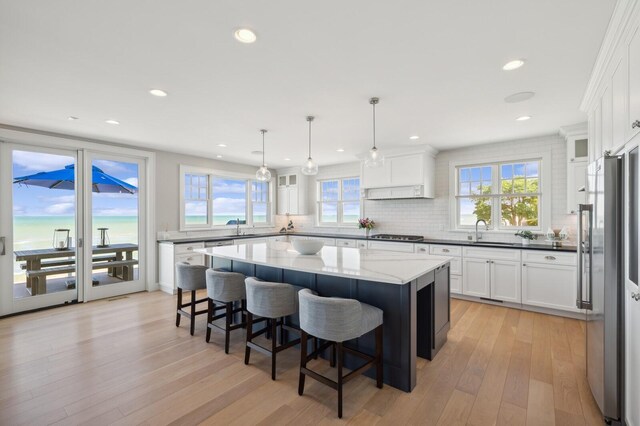 kitchen with tasteful backsplash, light wood-type flooring, a kitchen island, and freestanding refrigerator