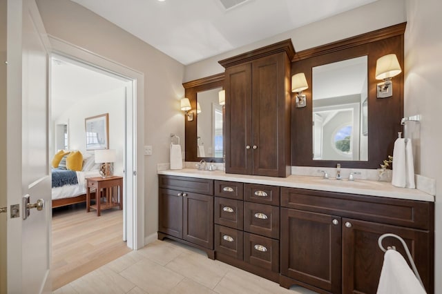 full bathroom with double vanity, tile patterned flooring, a sink, and connected bathroom