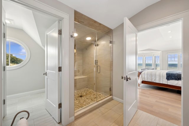 ensuite bathroom featuring a stall shower, plenty of natural light, vaulted ceiling, and ensuite bathroom