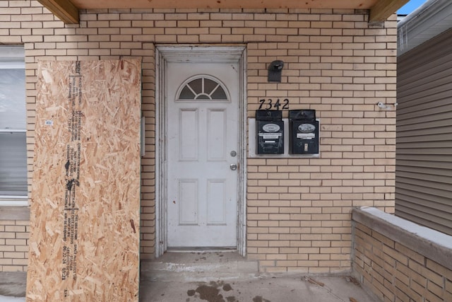 view of exterior entry featuring brick siding