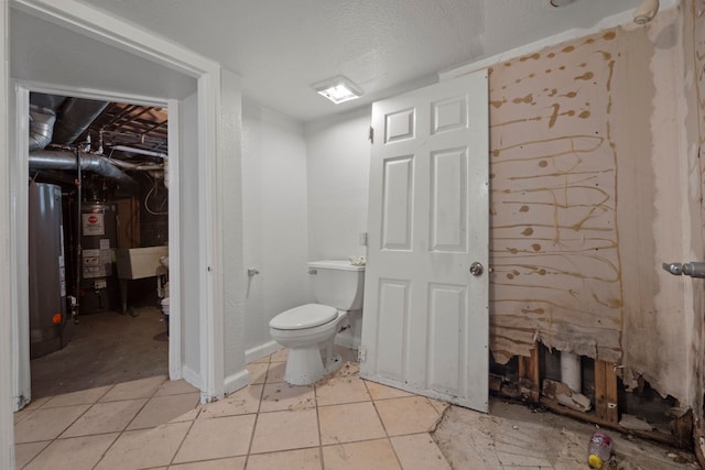 bathroom featuring toilet, water heater, a textured ceiling, and tile patterned floors