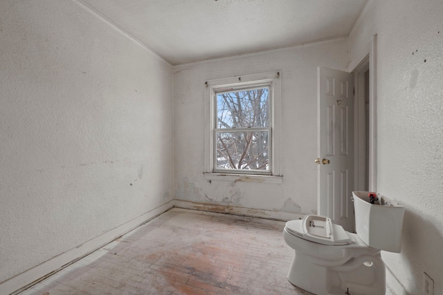 empty room featuring a textured wall and light wood-style flooring