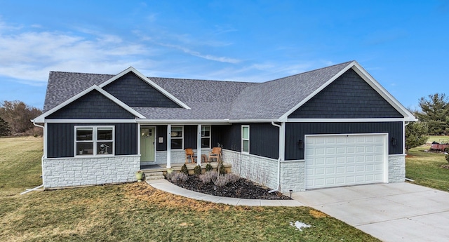 view of front of house with an attached garage, stone siding, a porch, and a front yard